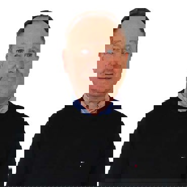 Man in a black sweater and blue shirt against a white background.