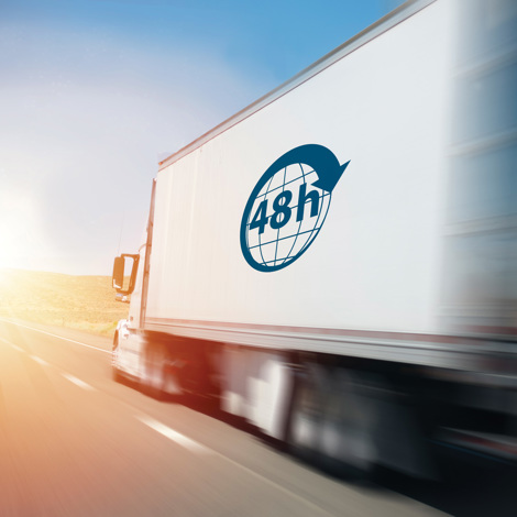 Truck with "48h" logo speeding down a highway at sunrise.
