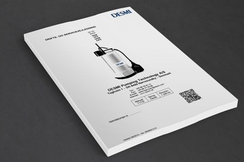 DESMI pump operation manual with contact details and QR code on cover.
