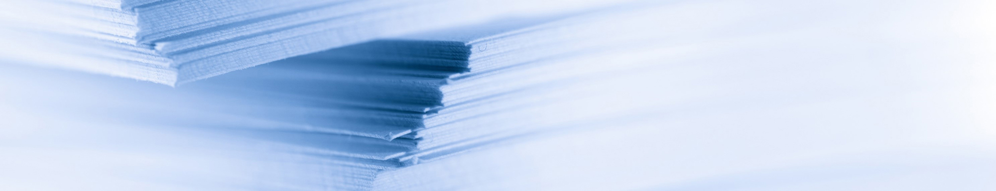 Close-up of stacked paper sheets with a soft blue tint.